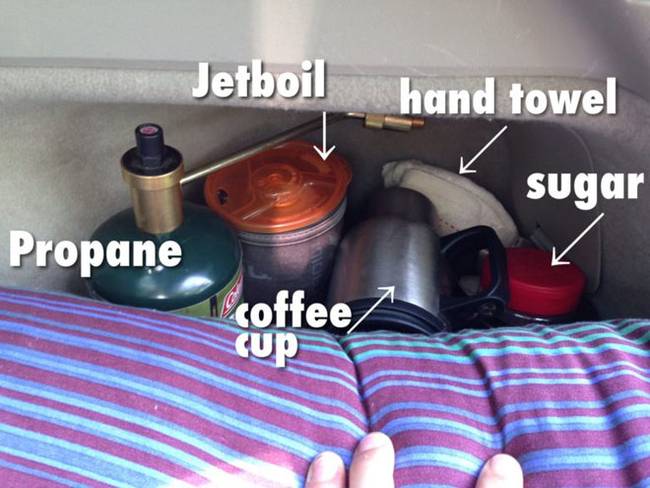 Интерьер дома на колёсах. А рядом с кроватью – ящик с чашкой, сахаром, кофе, полотенцем, и другими подобными вещами 