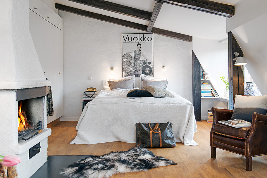Кровать в интерьере уютной мансарды в шведском городе