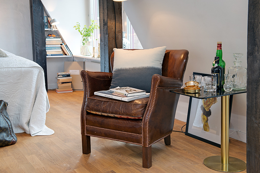 Кресло в интерьере уютной мансарды в шведском городе