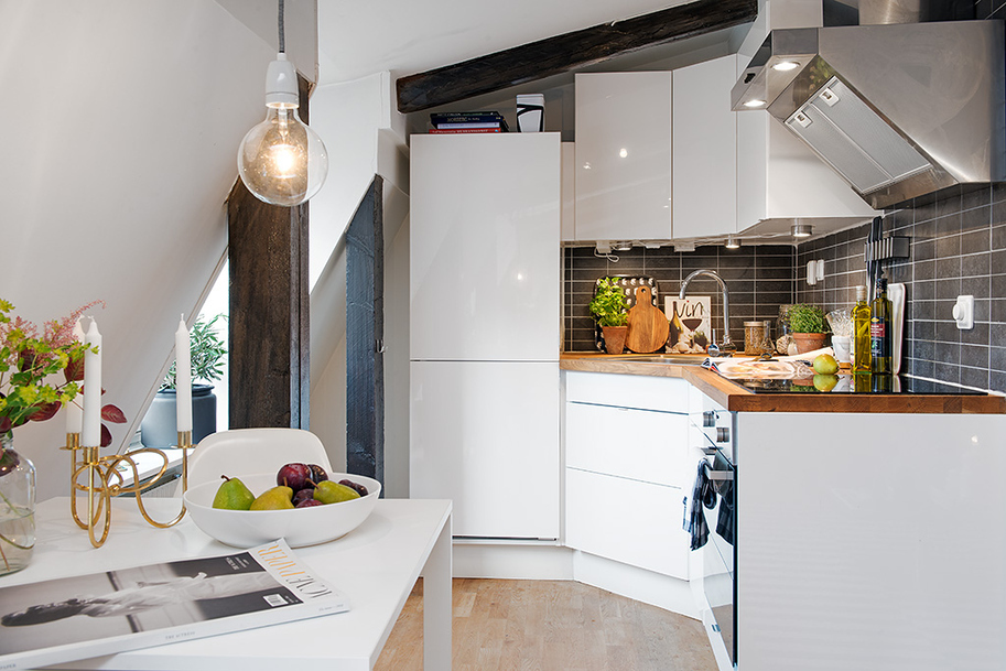 Кухонная зона в дизайне уютной мансарды в шведском городе