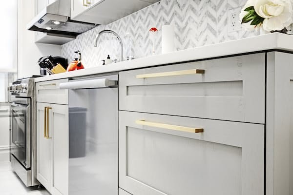 Серый кухонный гарнитур с золотыми ручками в узкой кухне