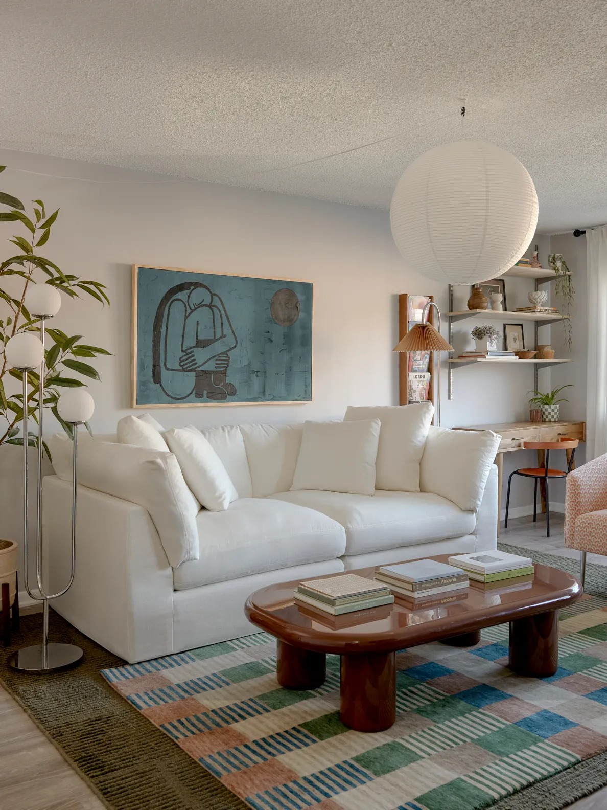 Гостиная с белым диваном журнальным столиком и растением The Modular Sofa