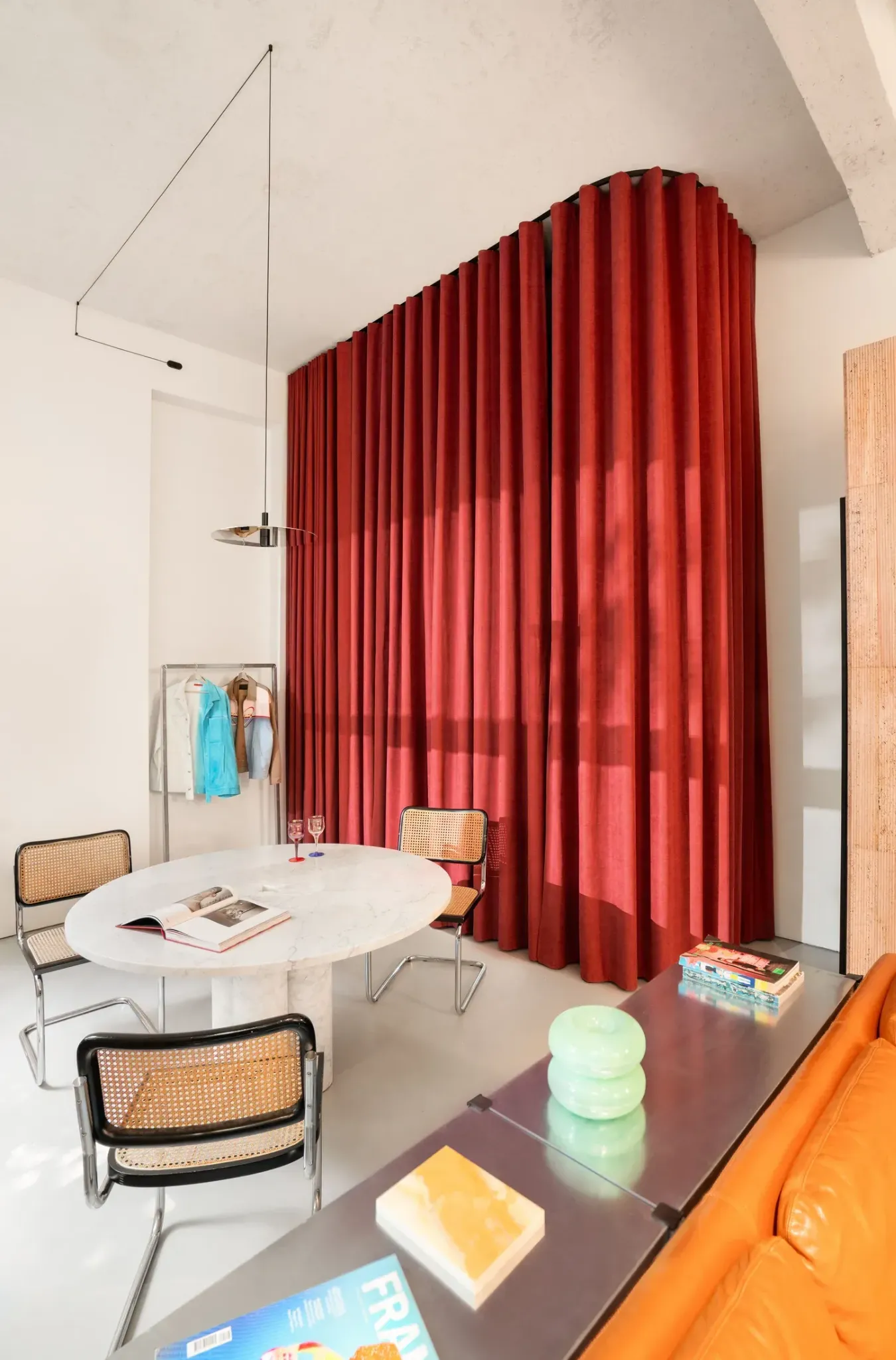 Гостиная с красной шторой и круглым столом 5 Bold Design Ideas Inside a Small Milan