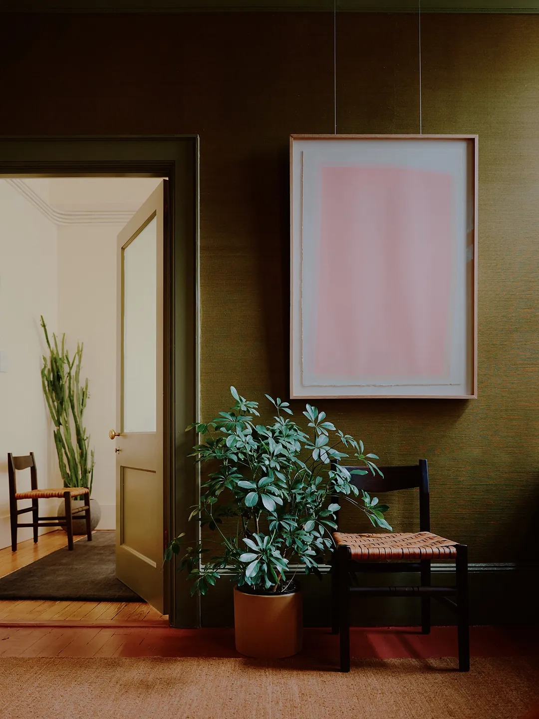 Интерьер с растением и стулом у стены Mismatched Doorknobs and Crimson Floors