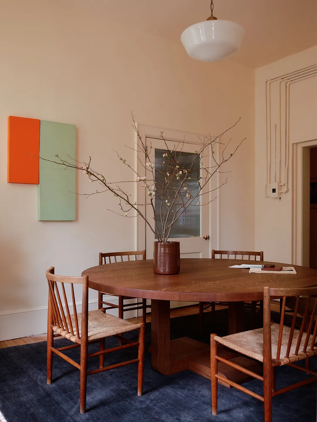 Столовая с круглым столом и деревянными стульями Mismatched Doorknobs and Crimson Floors