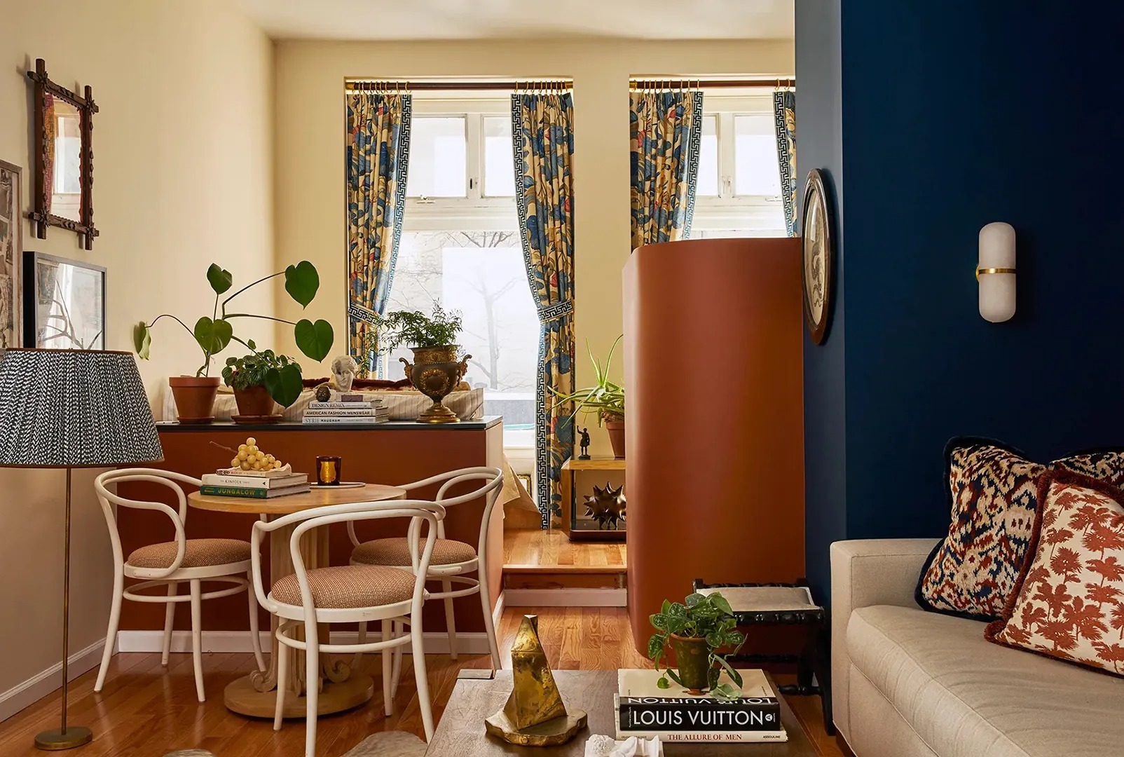 Уютная столовая зона с растениями и яркими шторами I’ve Covered Hundreds of Tiny Homes